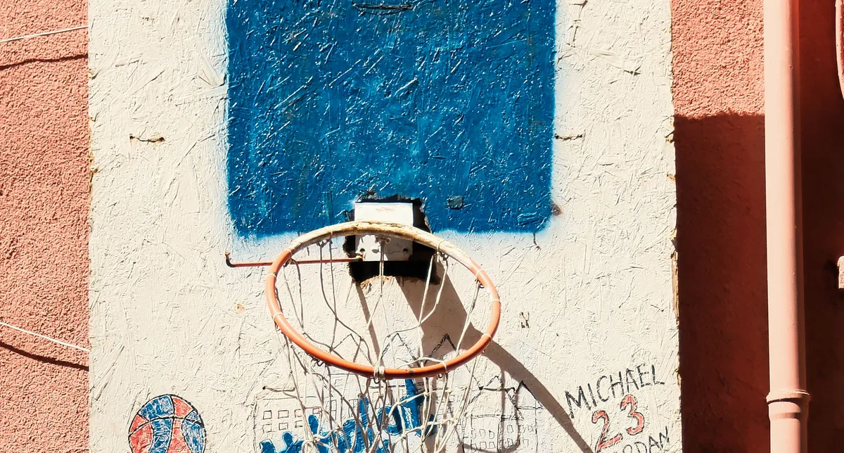 Street basketball hoop and painted backboard on a wall